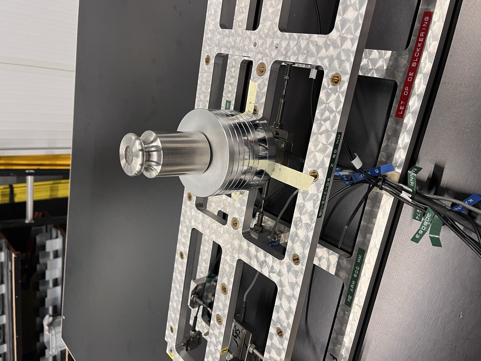Close-up of one of the balance's cylindrical load cells mounted in the frame