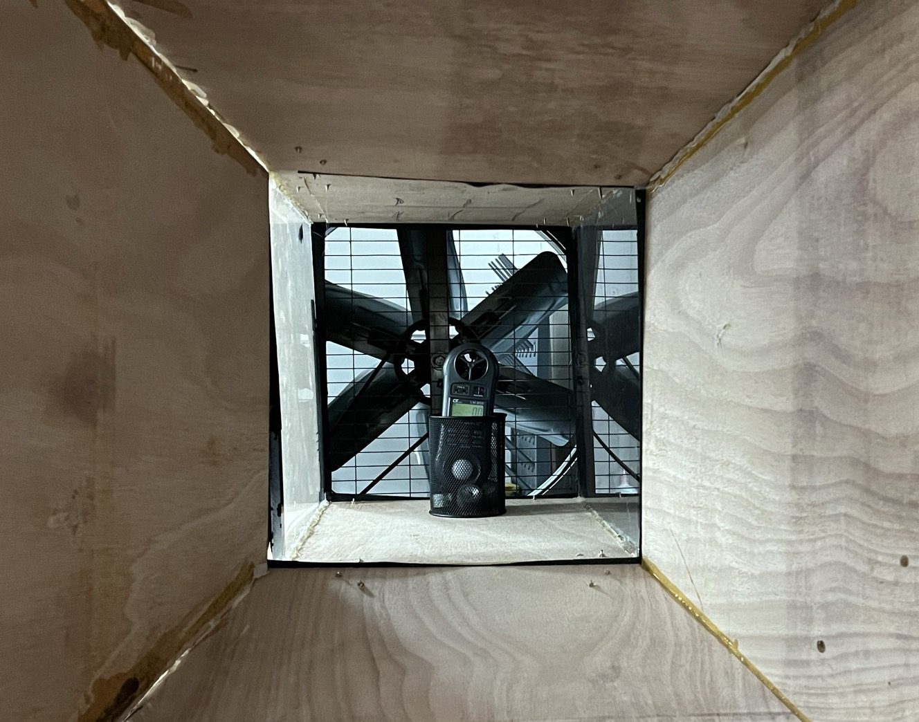 Looking down the inside of the self-built plywood wind tunnel towards its fan